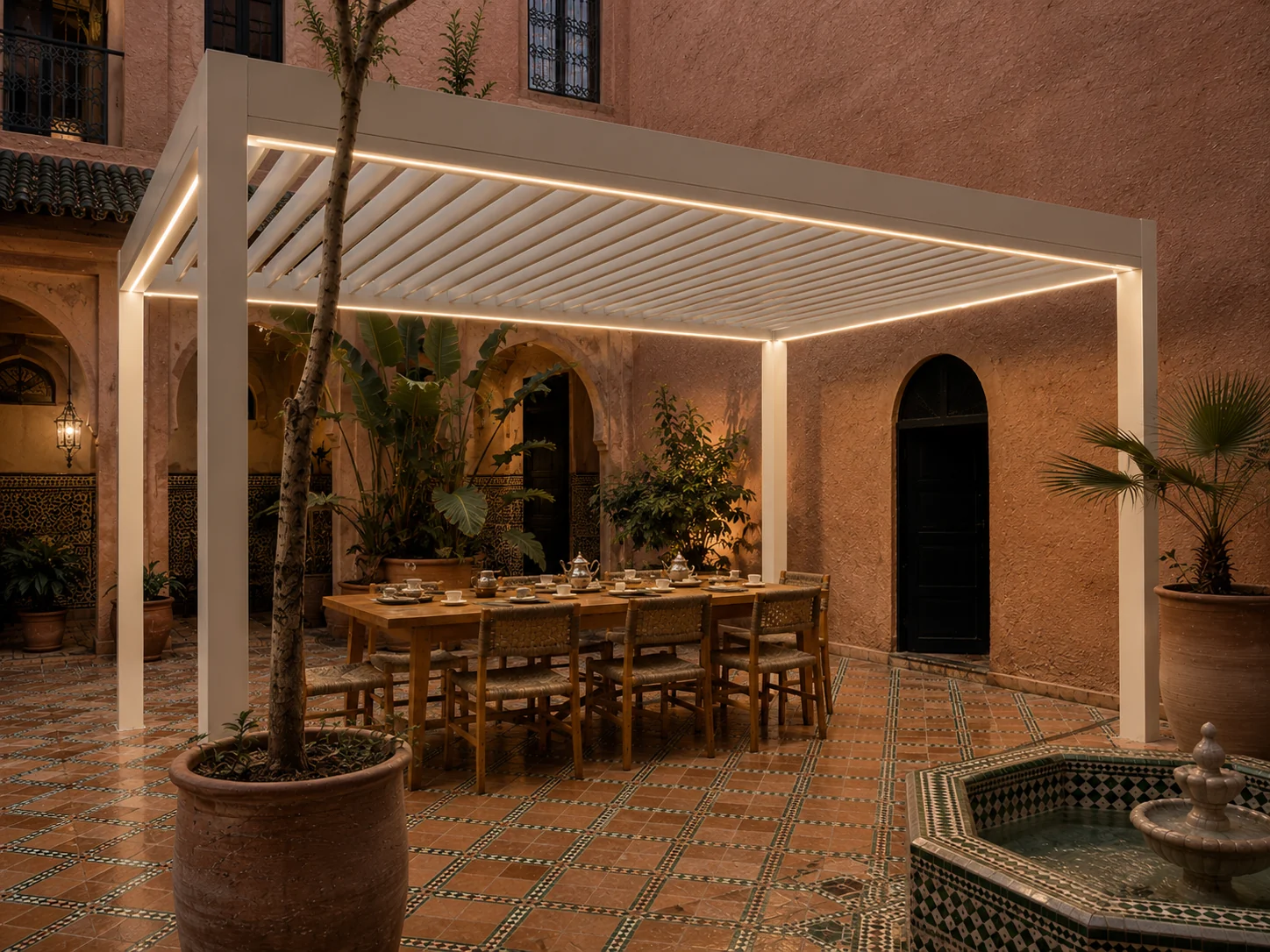 Pergola بيضاء في فناء رياض مغربي، طاولة طويلة مهيأة فوق أرضية من الزليج