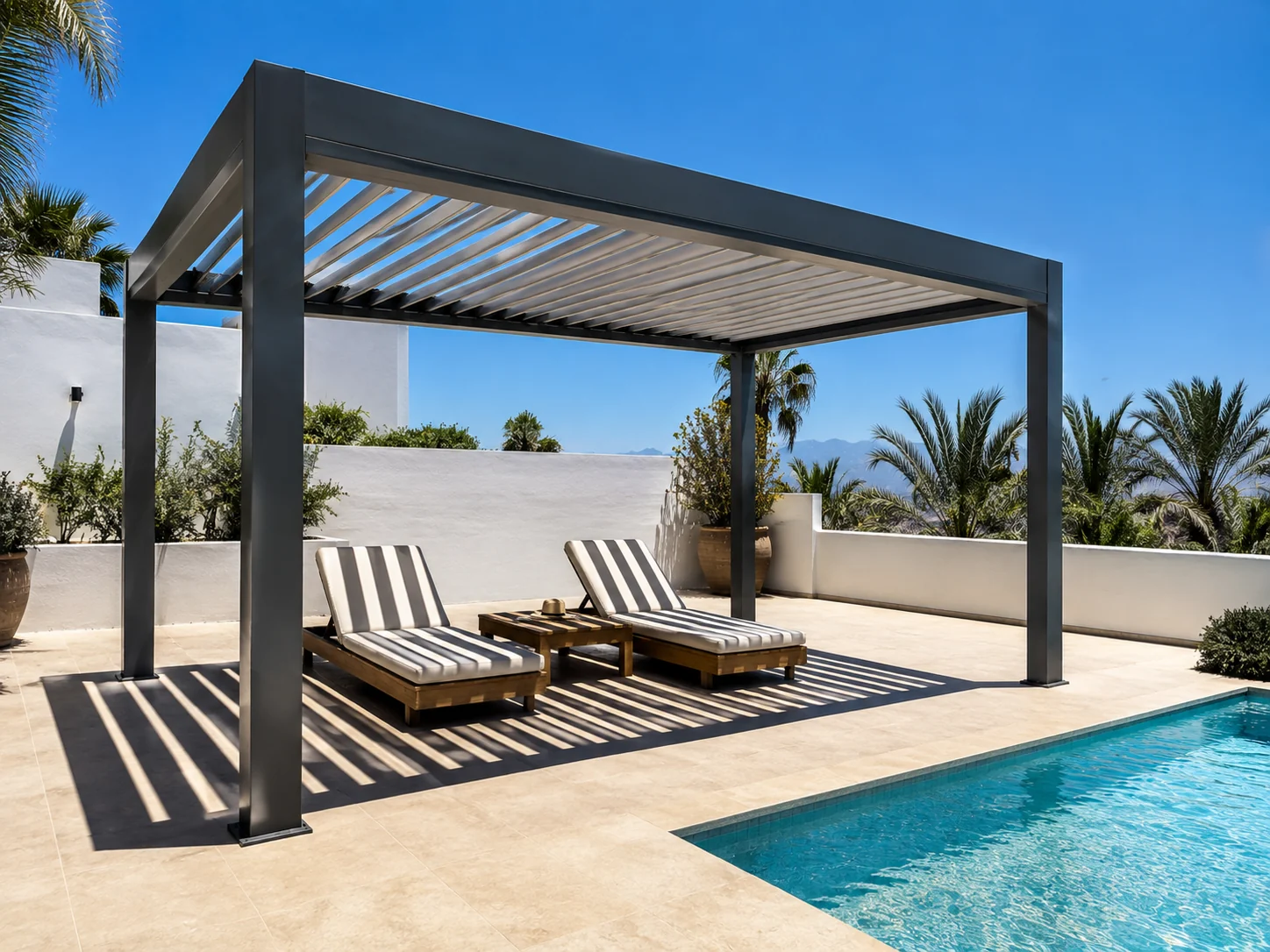 Pergola بيوكليماتيك رمادية بجانب المسبح، شفراتها نصف مفتوحة ترسم خطوط الظل على كرسيَي استلقاء